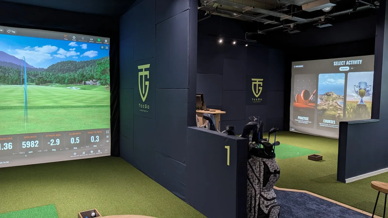 Indoor golf simulator bays at TeeGo Putney with hitting mats and projection screens